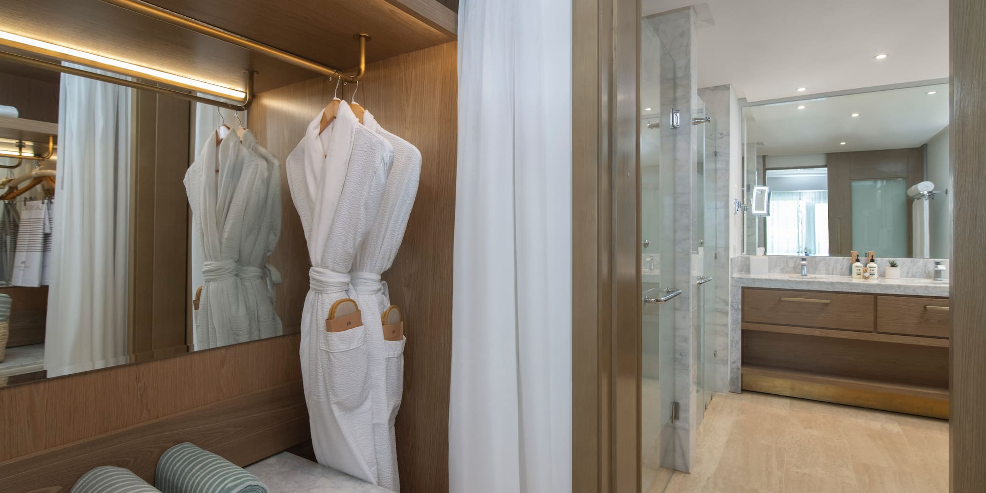 a bathroom with white bathrobes and towels