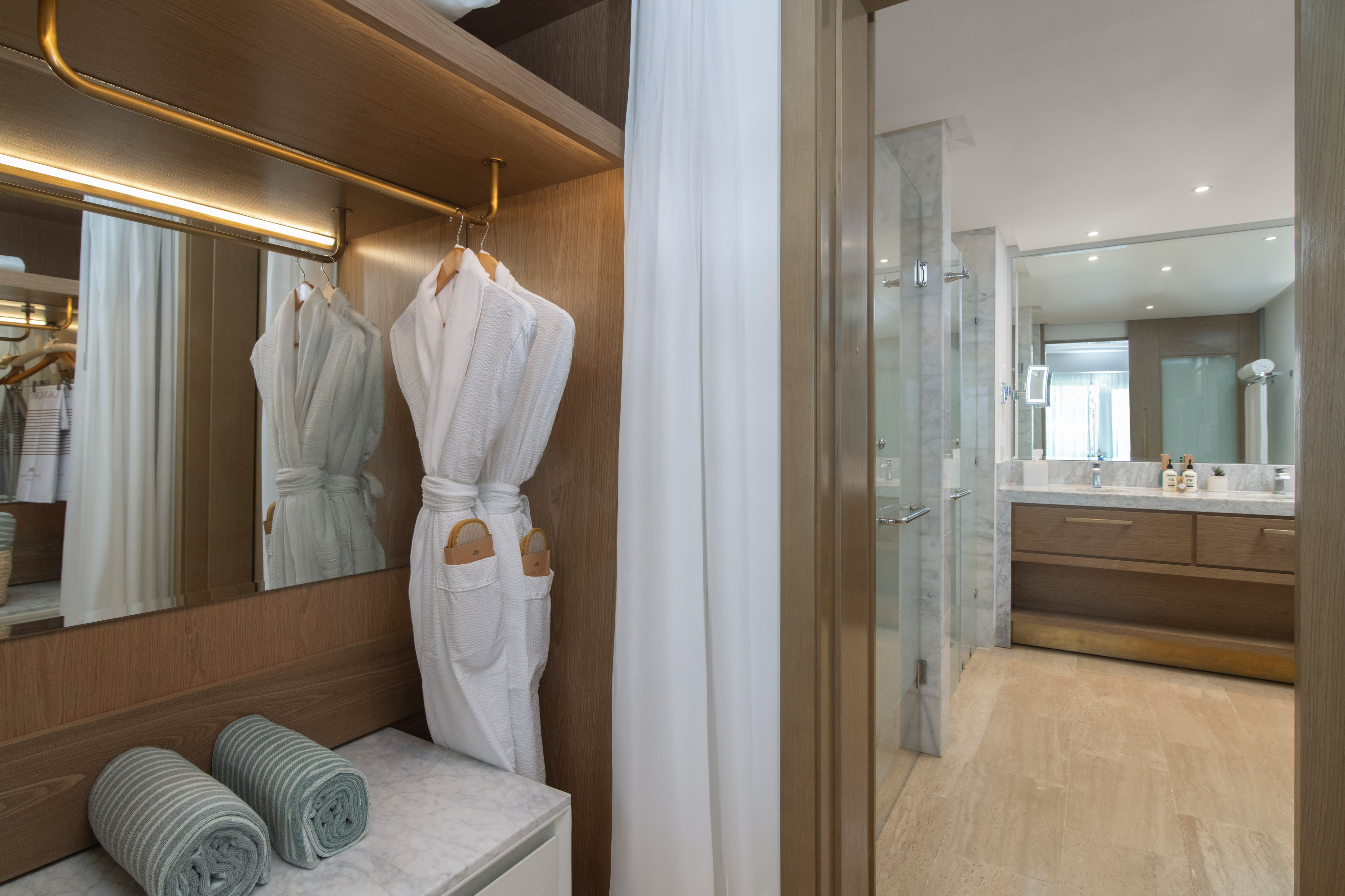 a bathroom with white bathrobes and towels