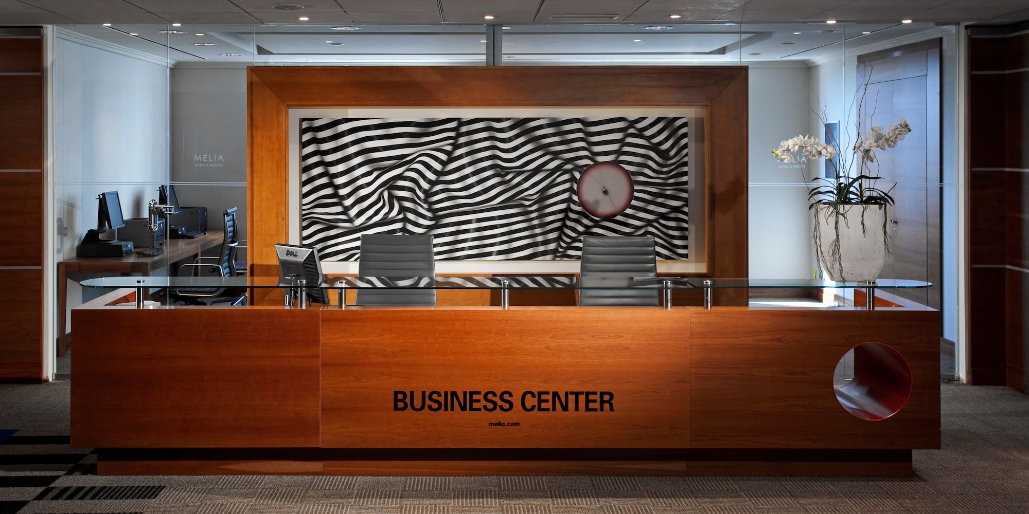 a desk with chairs and a clock in front of it