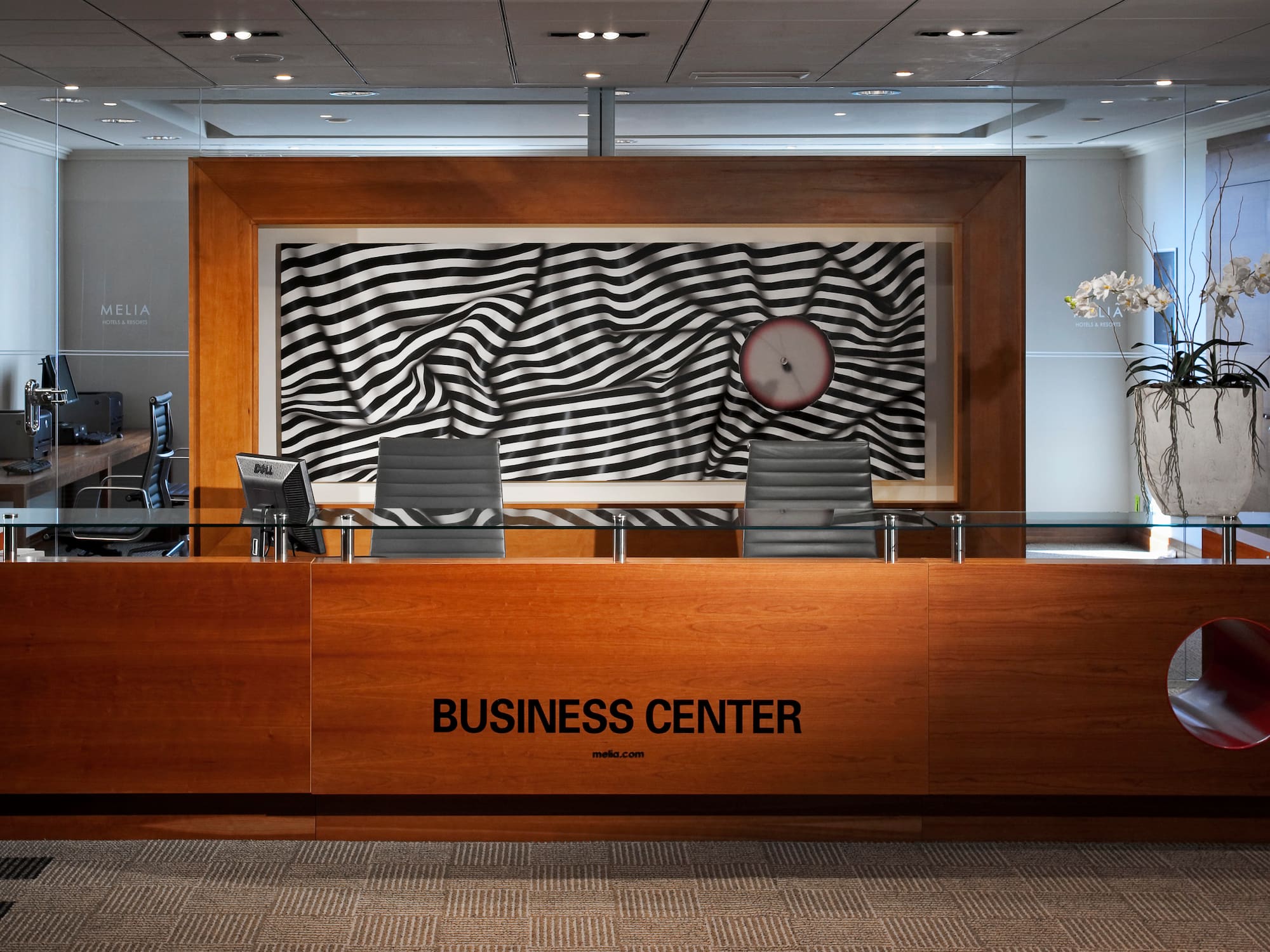 a desk with chairs and a clock in front of it