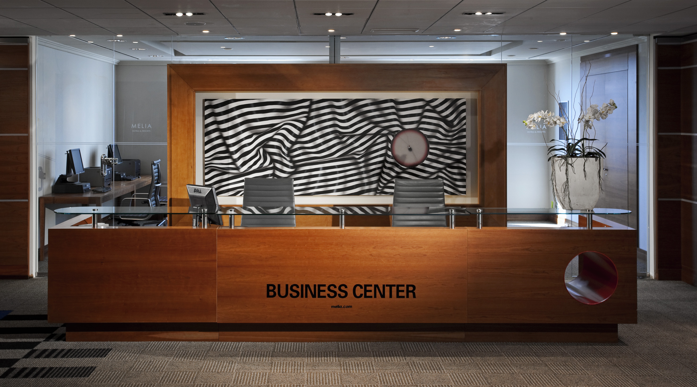 a desk with chairs and a clock in front of it