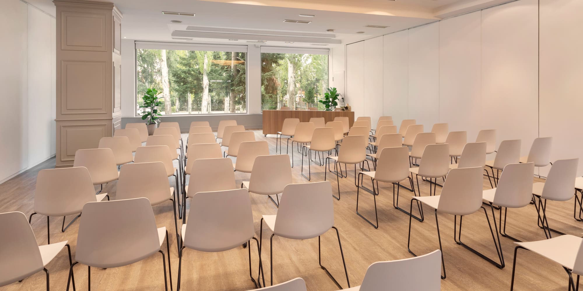 a room with white chairs and a large window