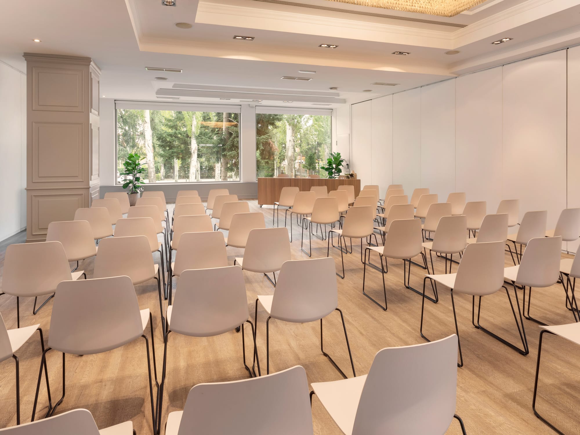 a room with white chairs and a large window