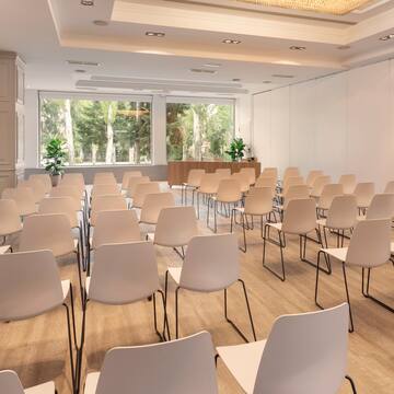 a room with white chairs and a large window