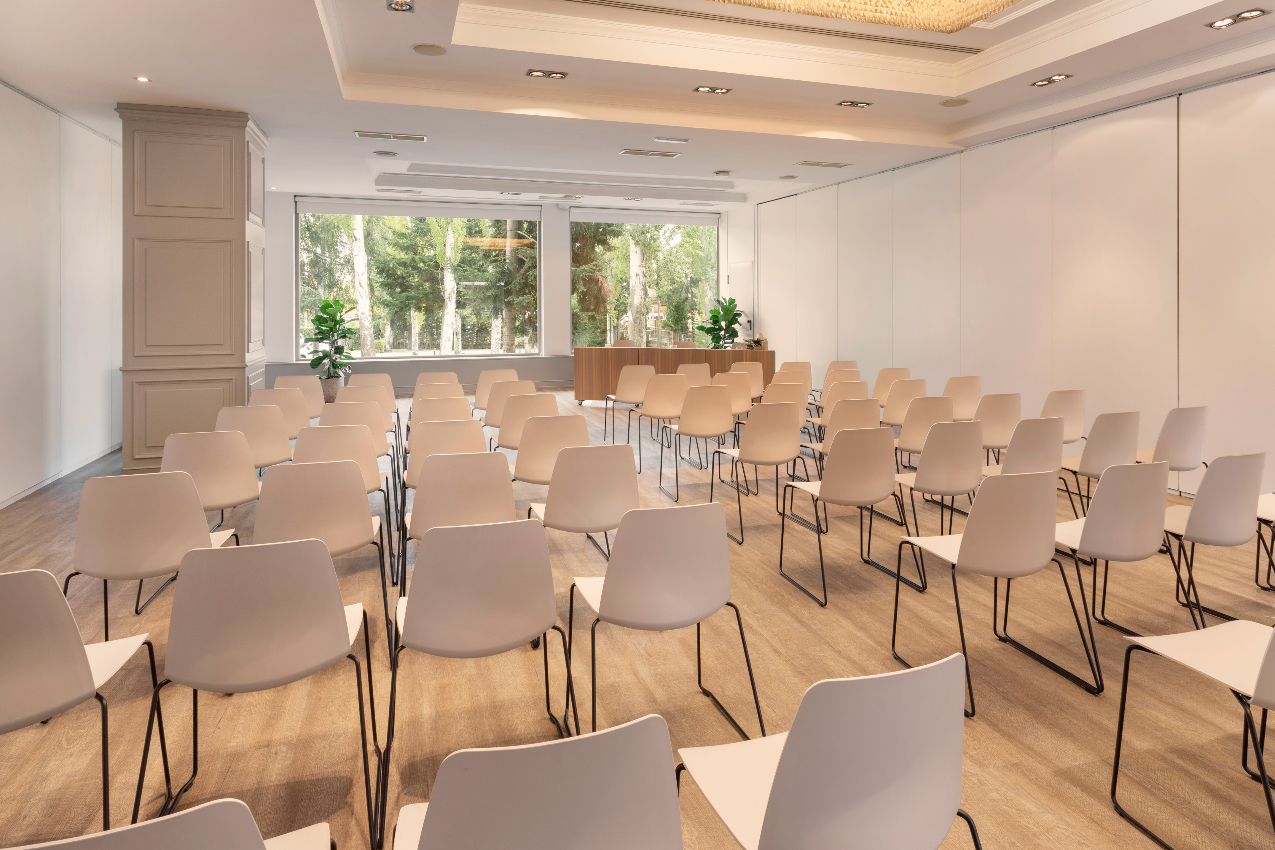 a room with white chairs and a large window
