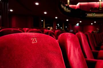 a red theater seats with number on the back