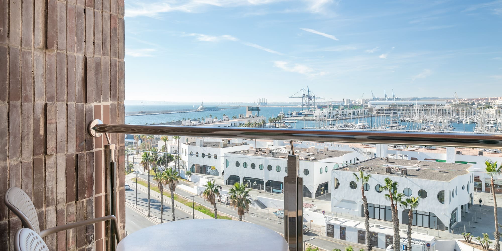 a table and railing on a balcony overlooking a city