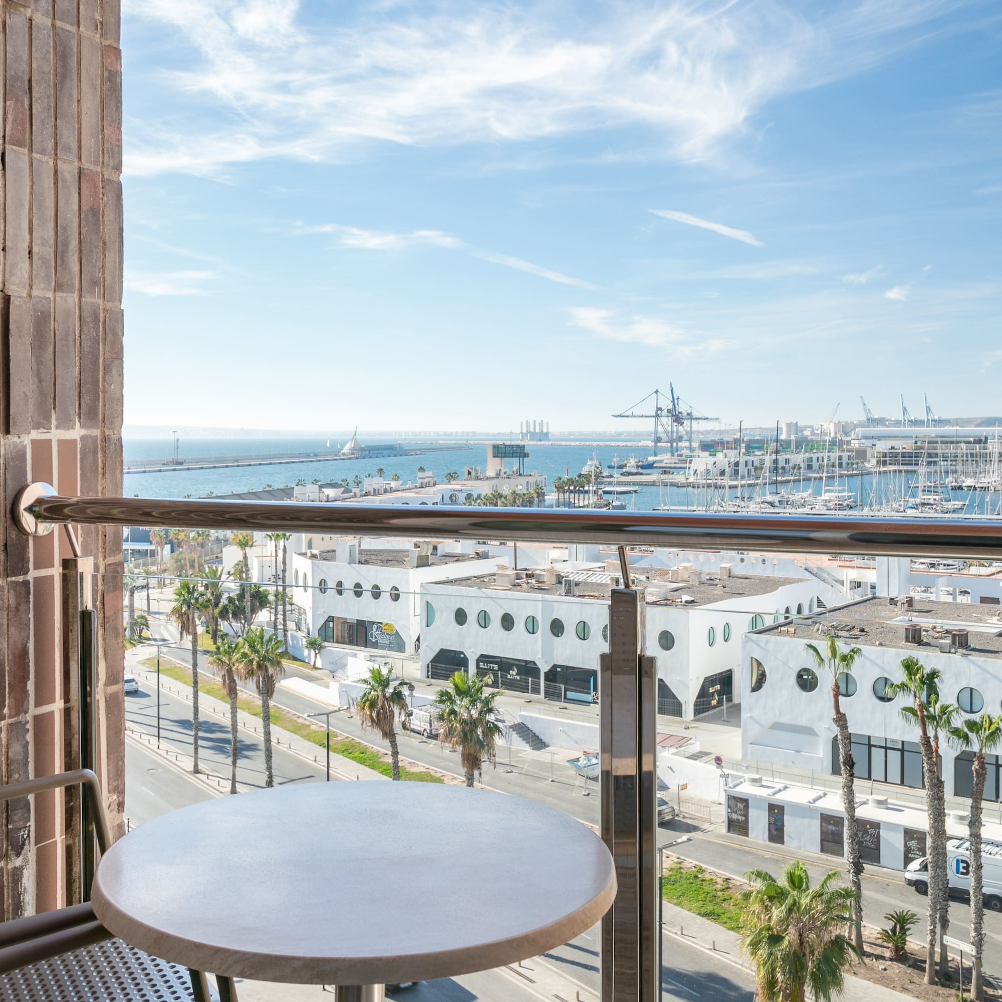 a table and railing on a balcony overlooking a city