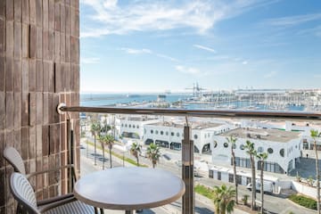 a table and railing on a balcony overlooking a city