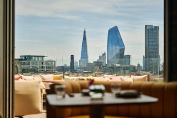 a table and chairs with a city skyline in the background