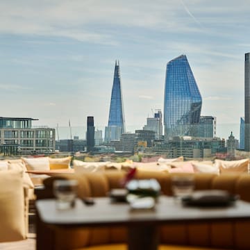 a table and chairs with a city skyline in the background