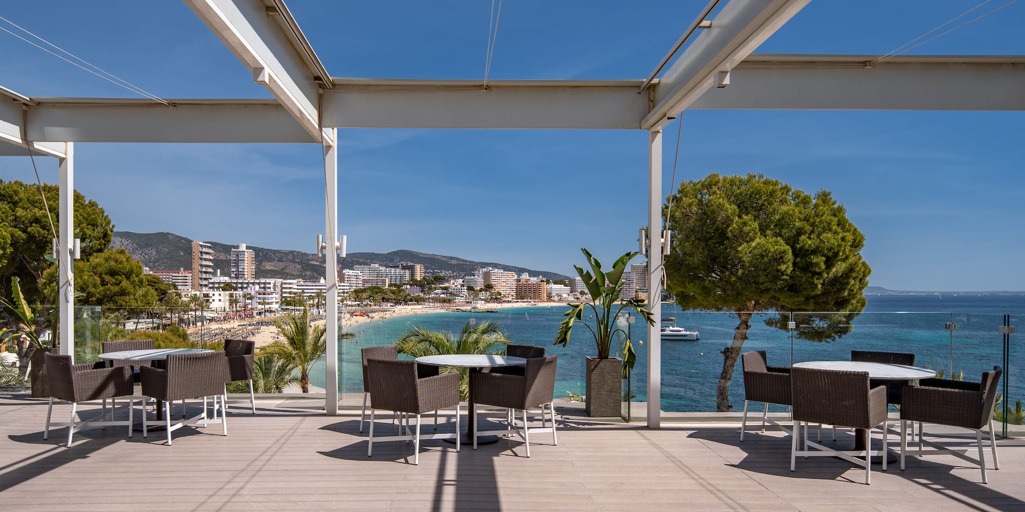 a patio with chairs and tables on a sunny day