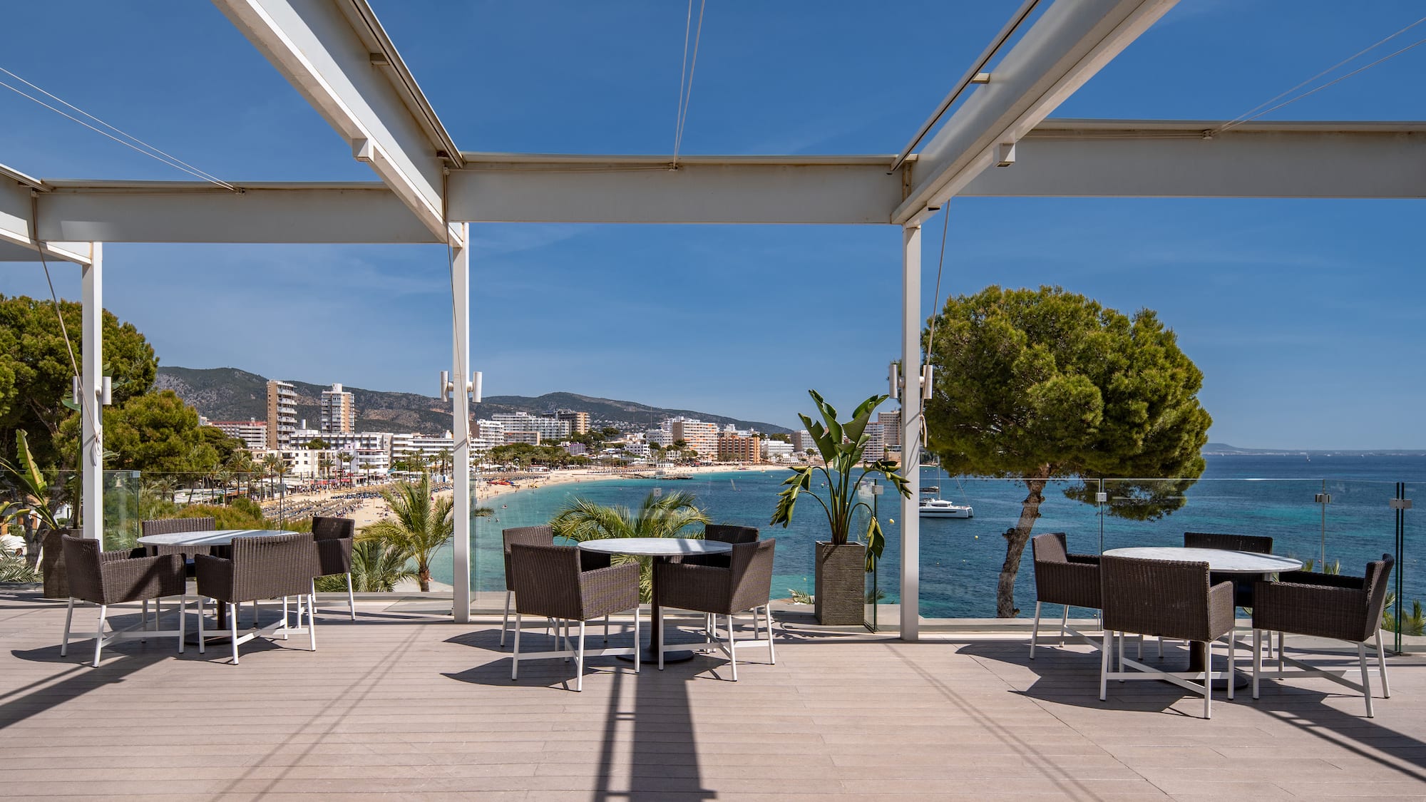 a patio with chairs and tables on a sunny day