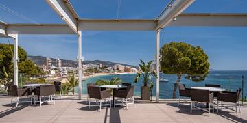 a patio with chairs and tables on a sunny day