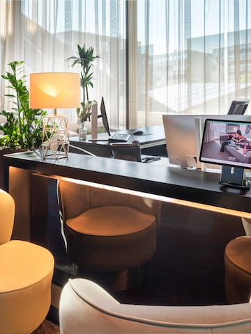 a room with a desk and chairs and a computer