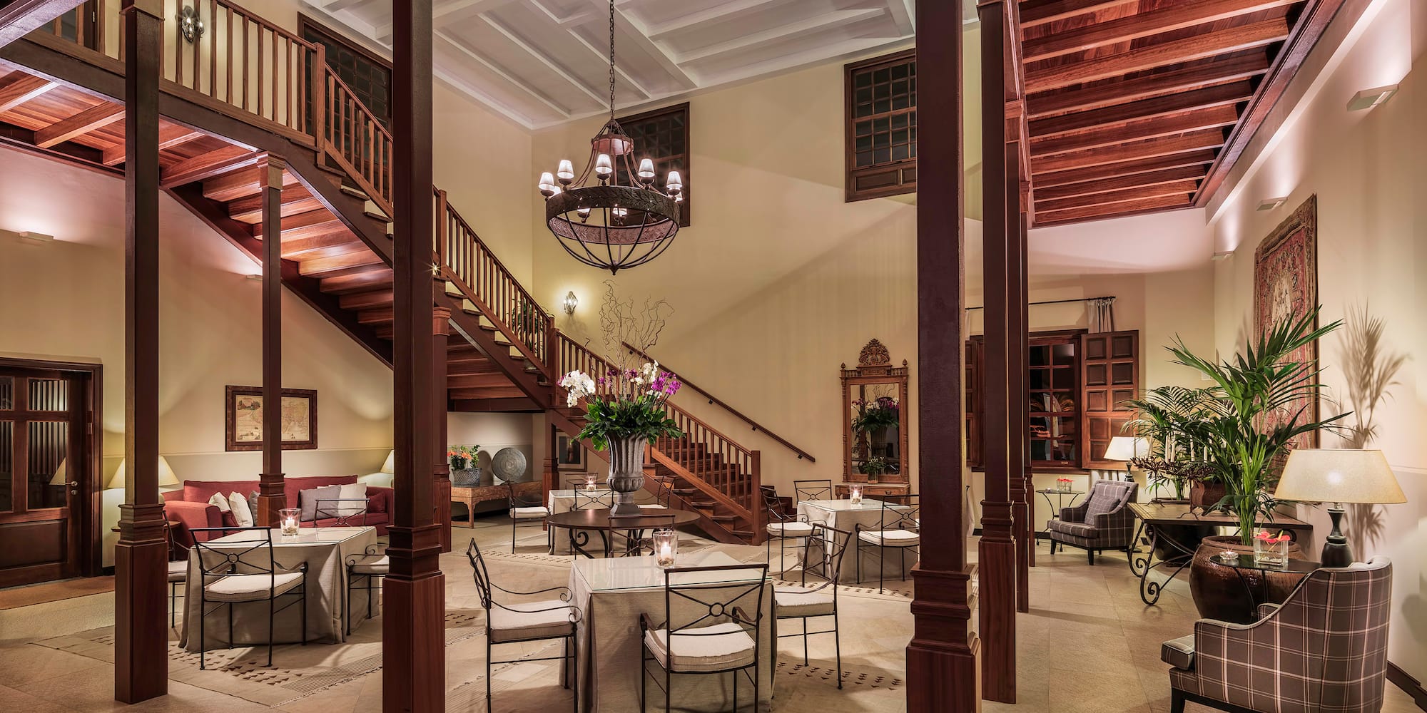 a room with stairs and tables and chairs