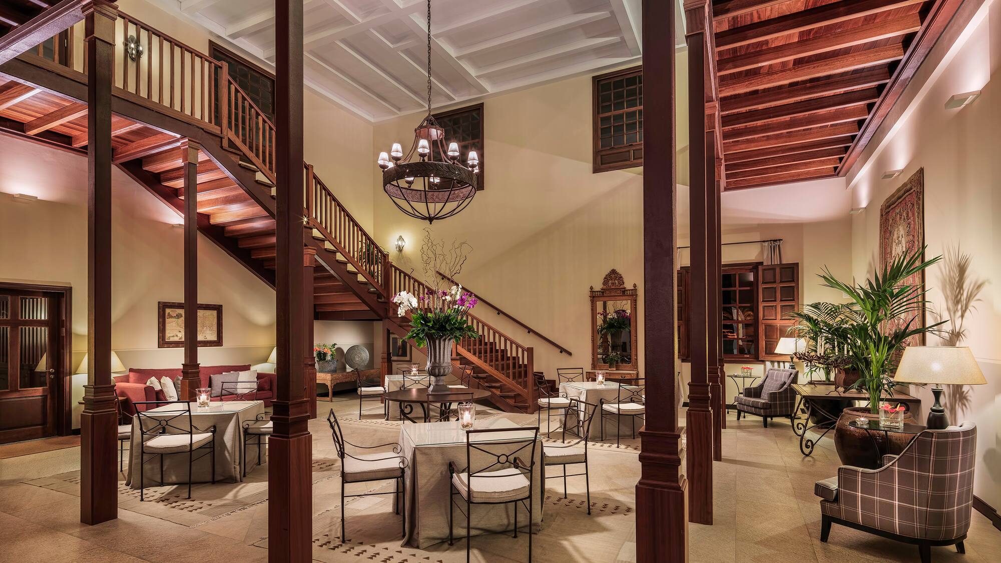 a room with stairs and tables and chairs