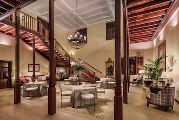 a room with stairs and tables and chairs