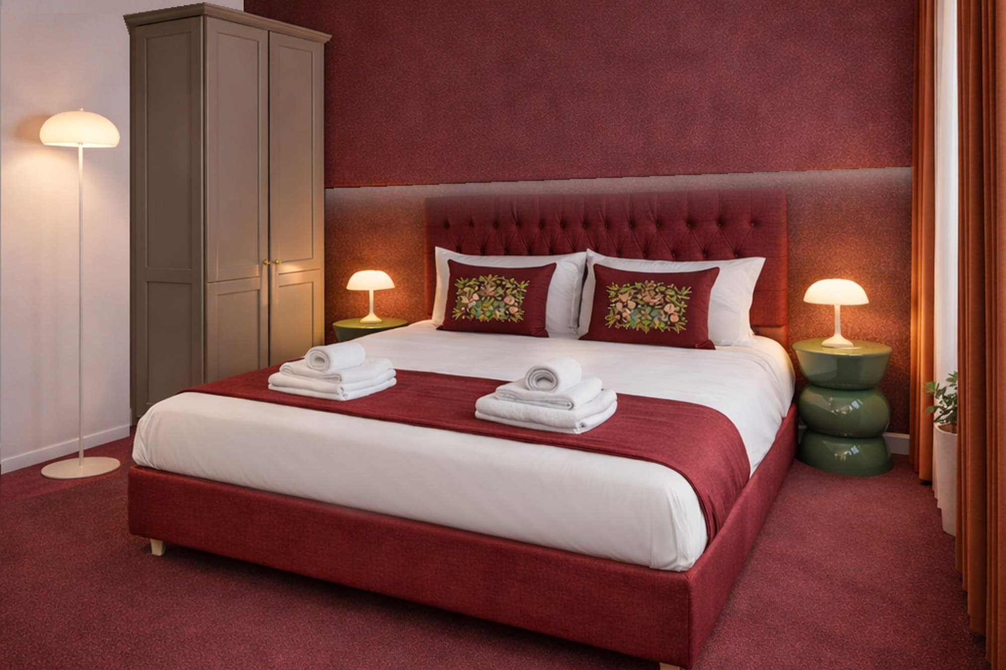a bed with red carpet and lamps