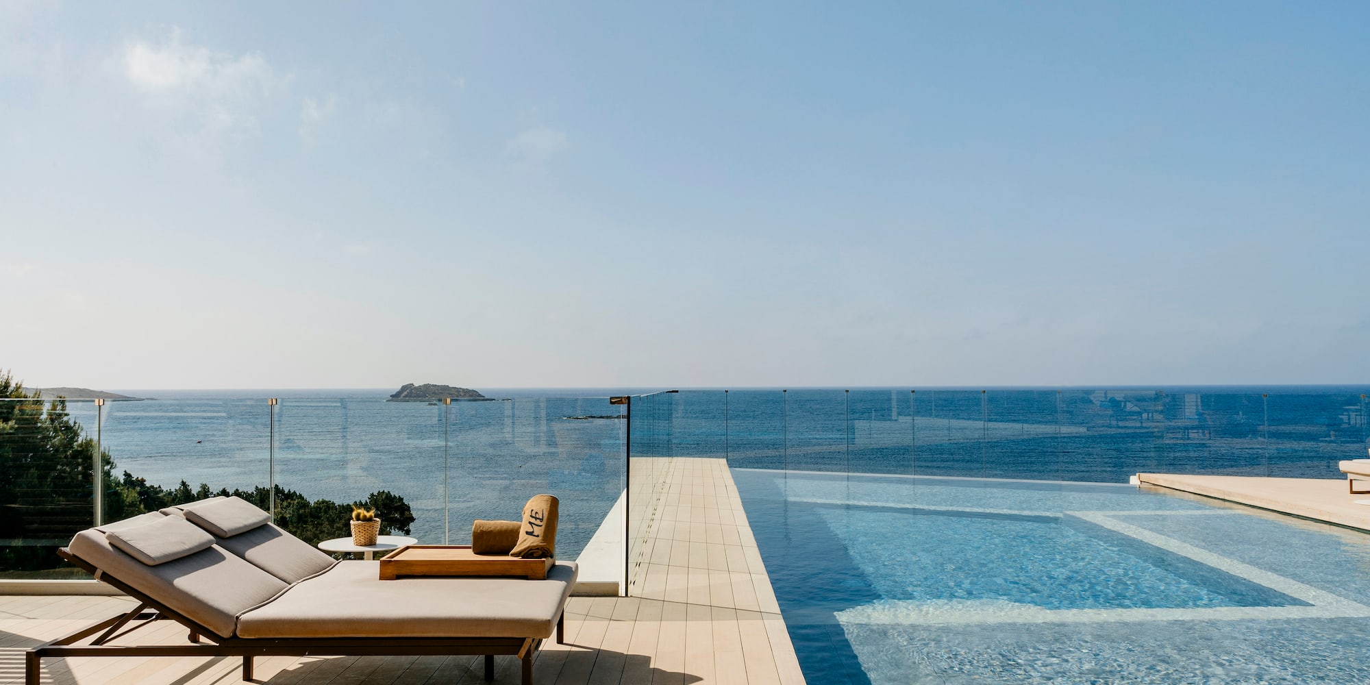 a pool with a deck chair and a glass fence