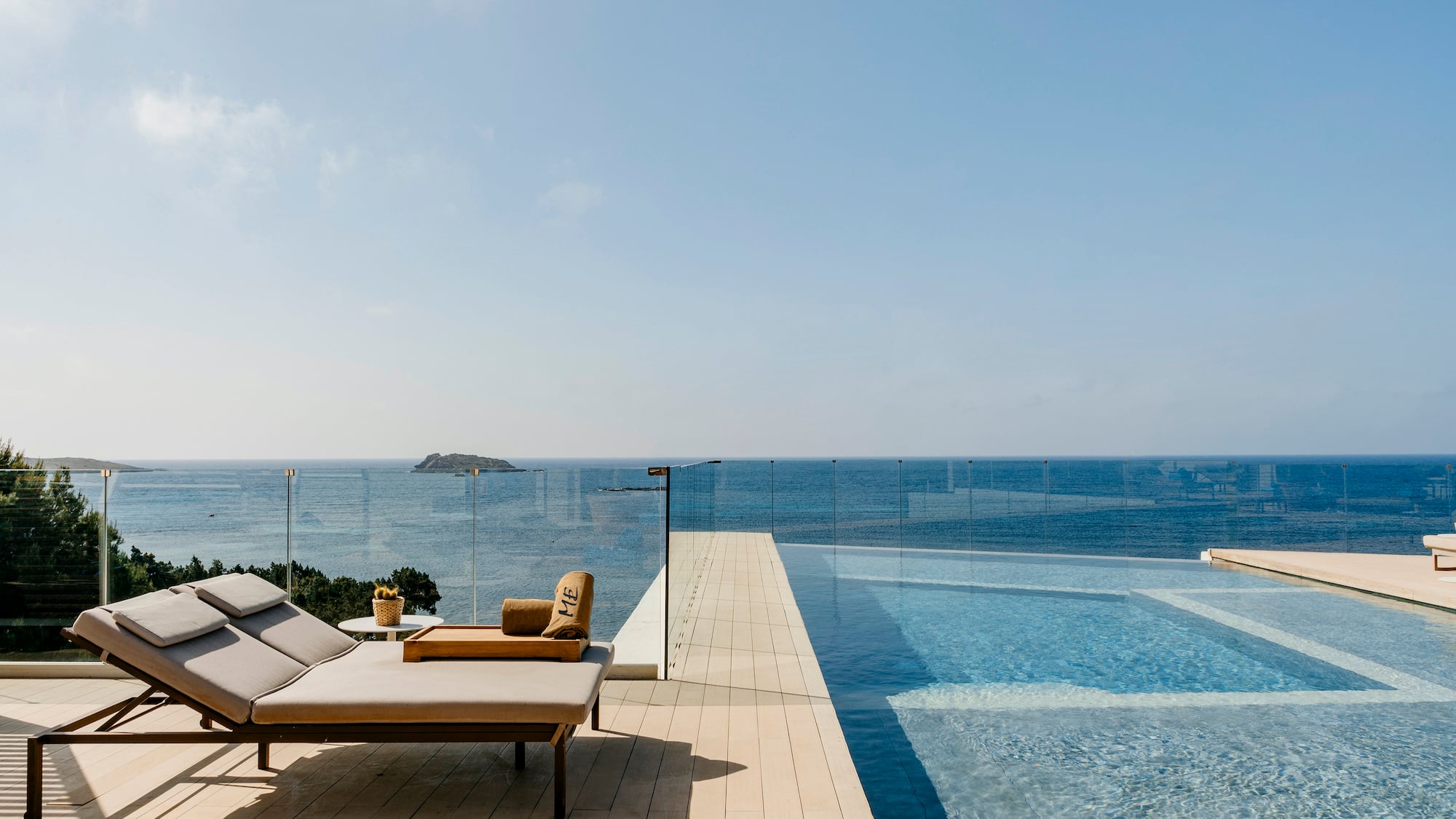 a pool with a deck chair and a glass fence