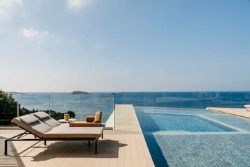 a pool with a deck chair and a glass fence