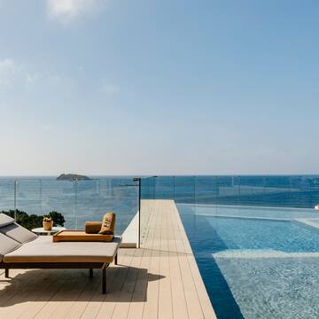 a pool with a deck chair and a glass fence