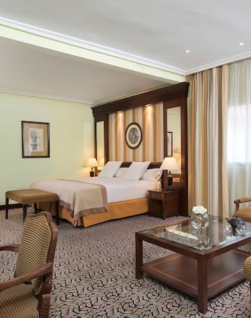 a room with a bed and chairs