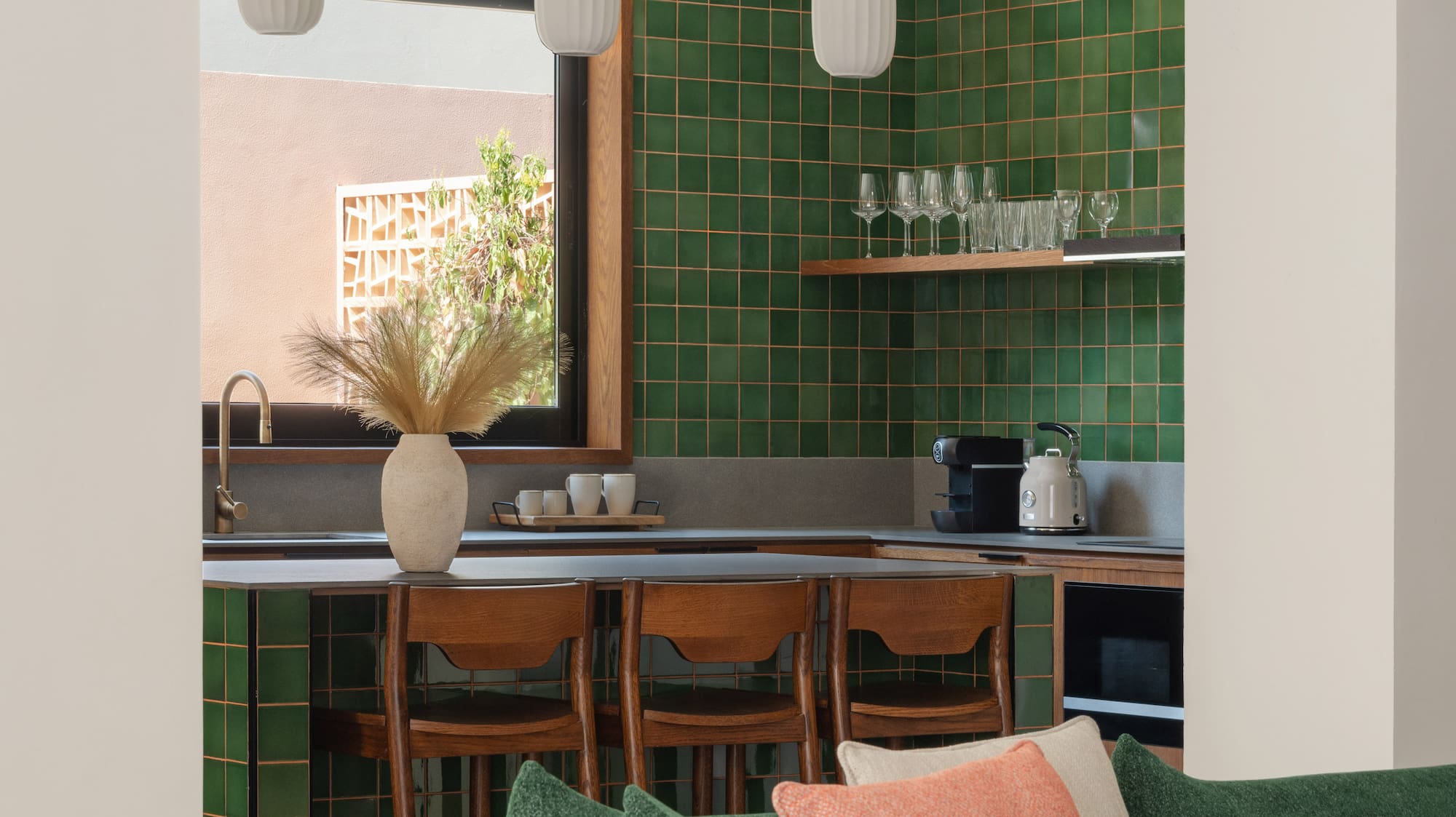 a kitchen with green tiles and a couch