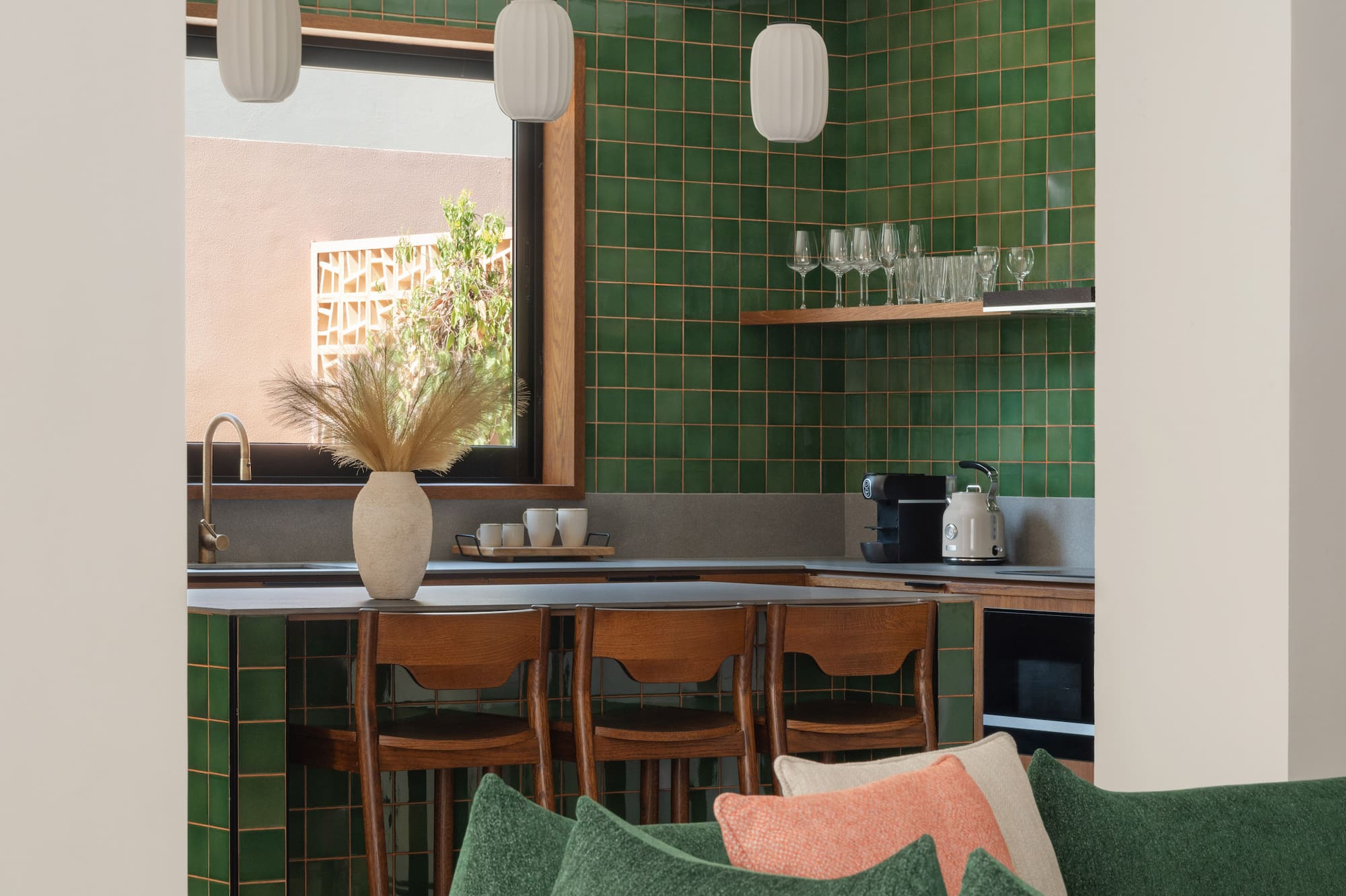 a kitchen with green tiles and a couch