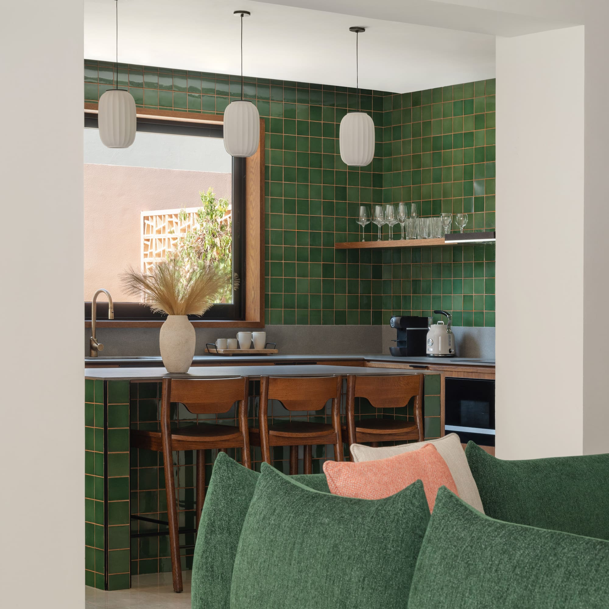 a kitchen with green tiles and a couch