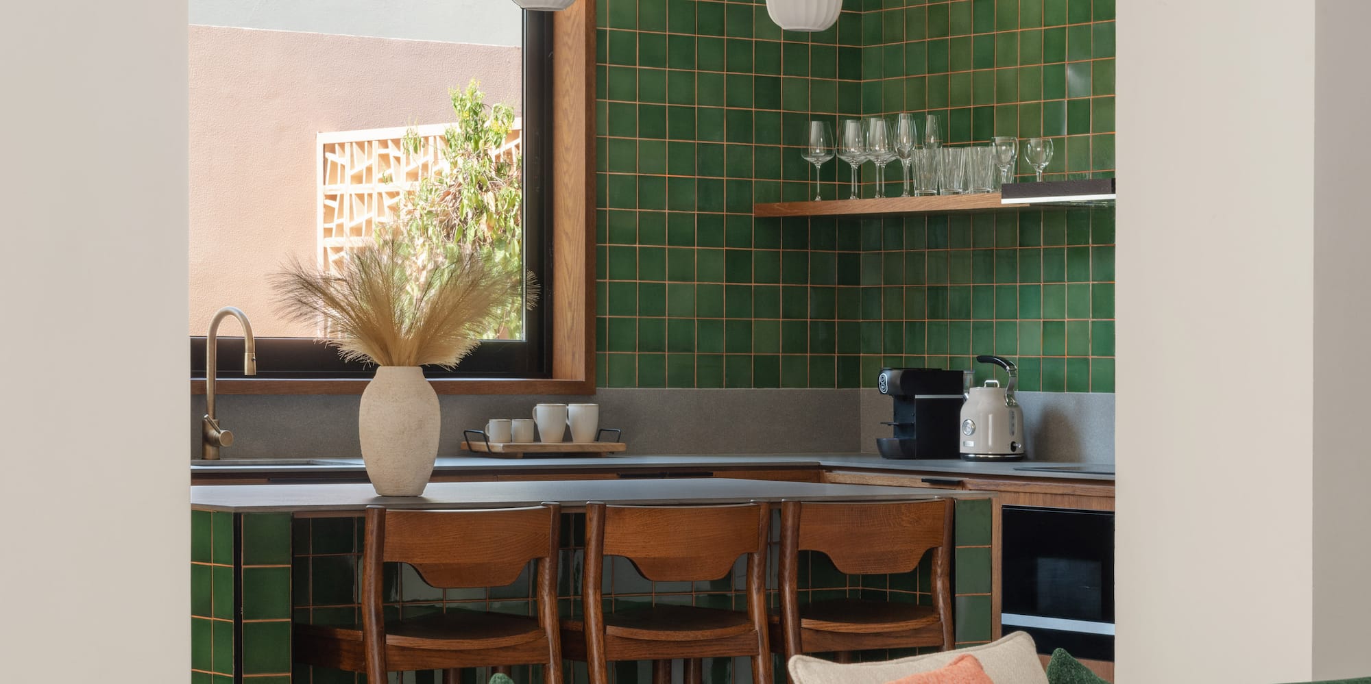 a kitchen with green tiles and a couch