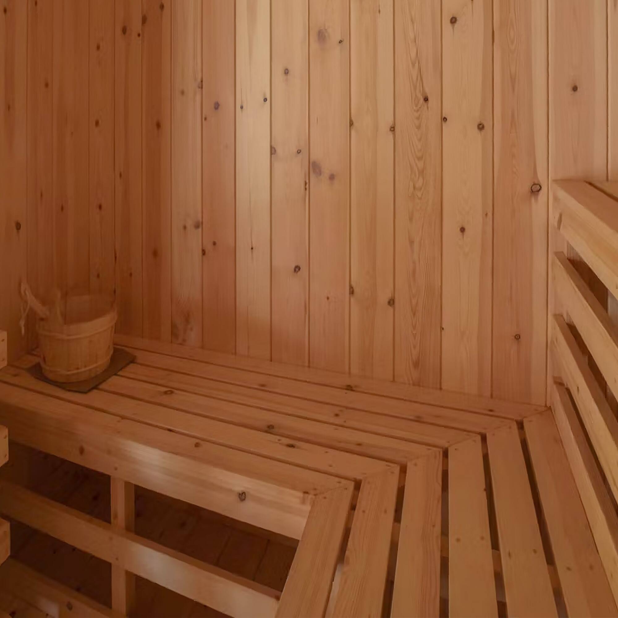 a wooden sauna with a bucket and a bucket