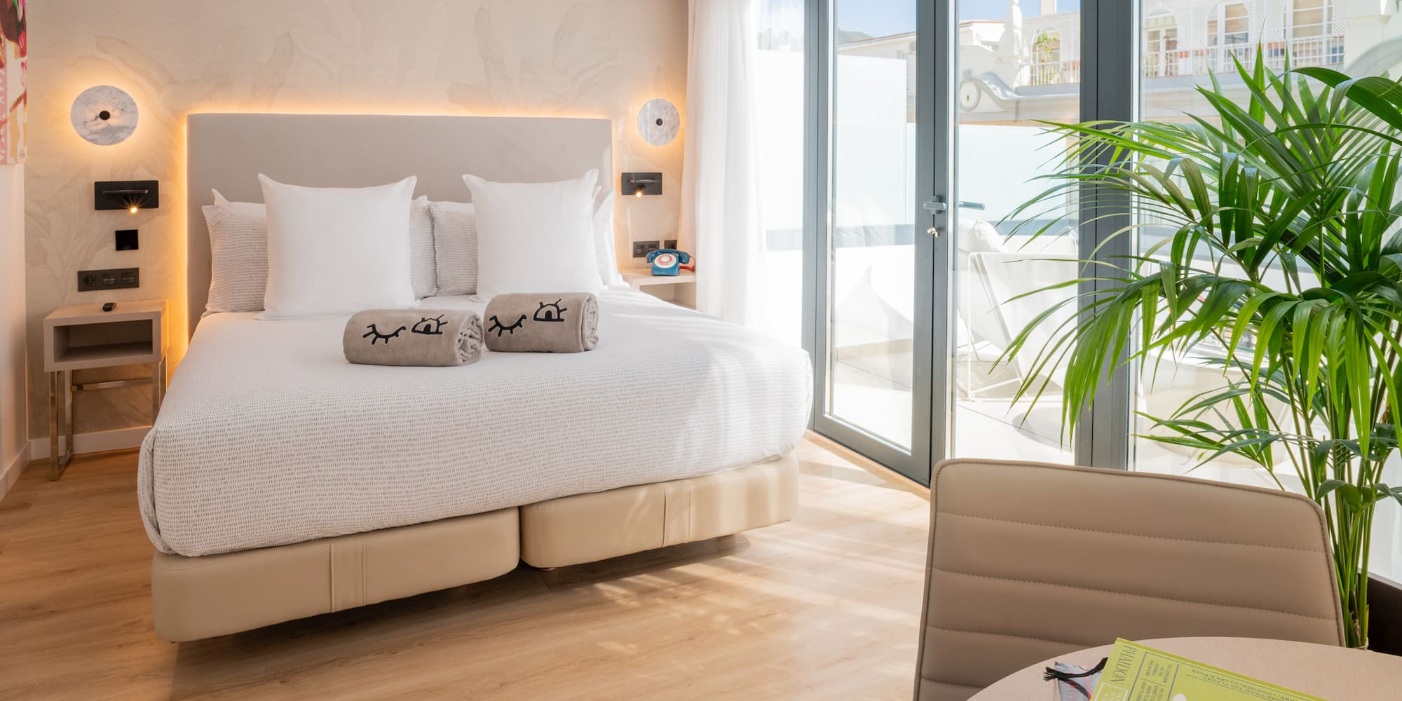 a bed with pillows and a plant in a room