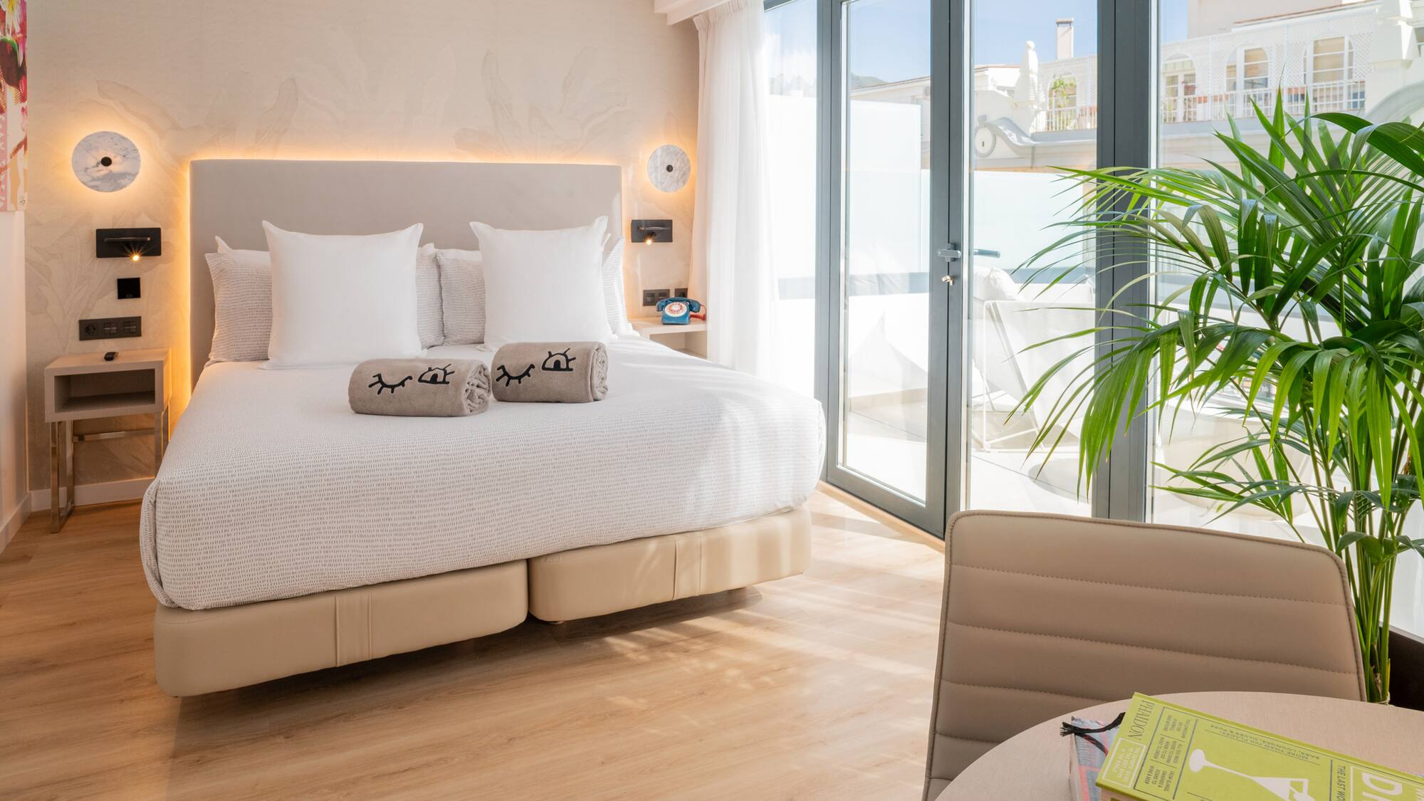 a bed with pillows and a plant in a room