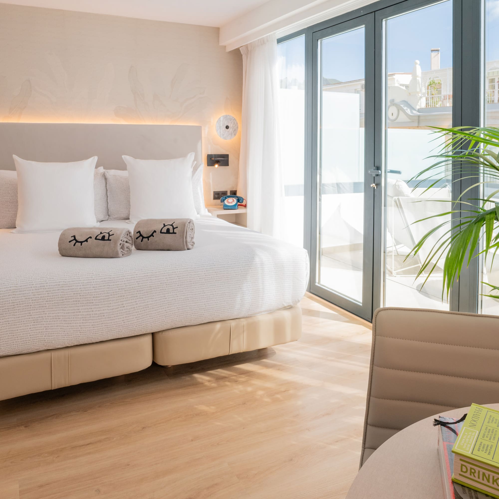 a bed with pillows and a plant in a room