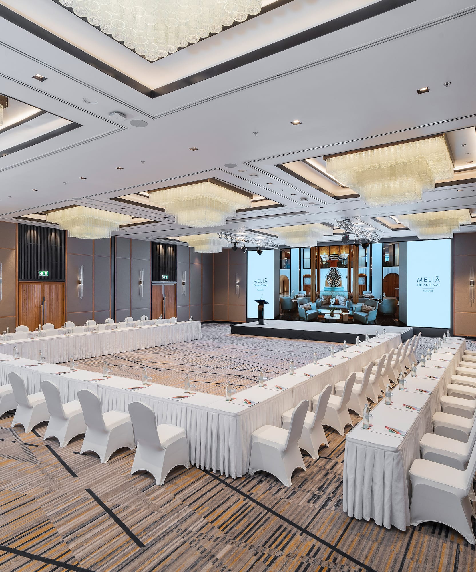 Meliá Chiang Mai ballroom with U-shaped conference setup, large screen.