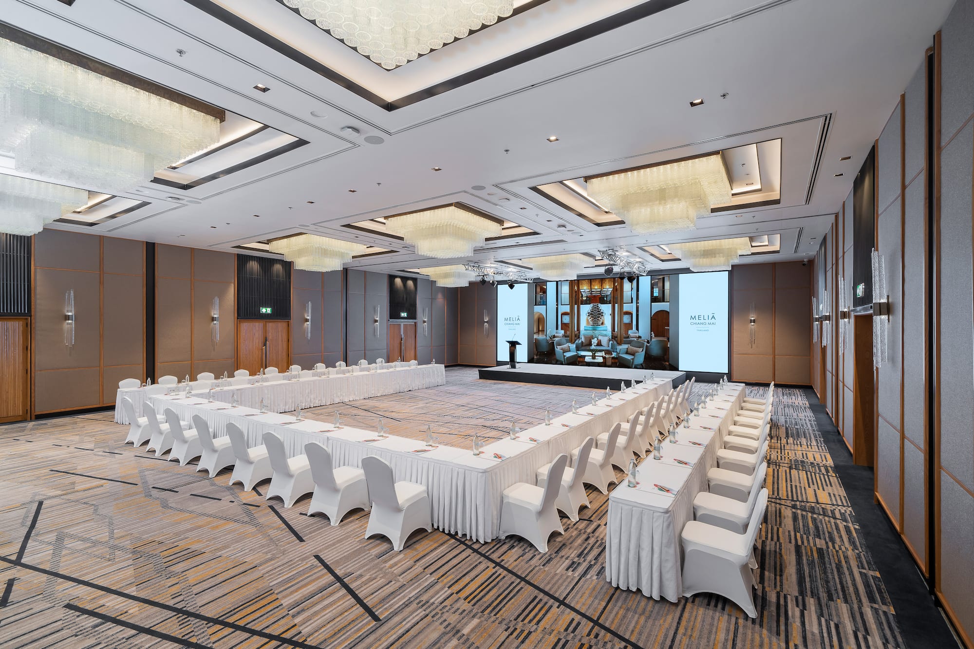 Meliá Chiang Mai ballroom with U-shaped conference setup, large screen.