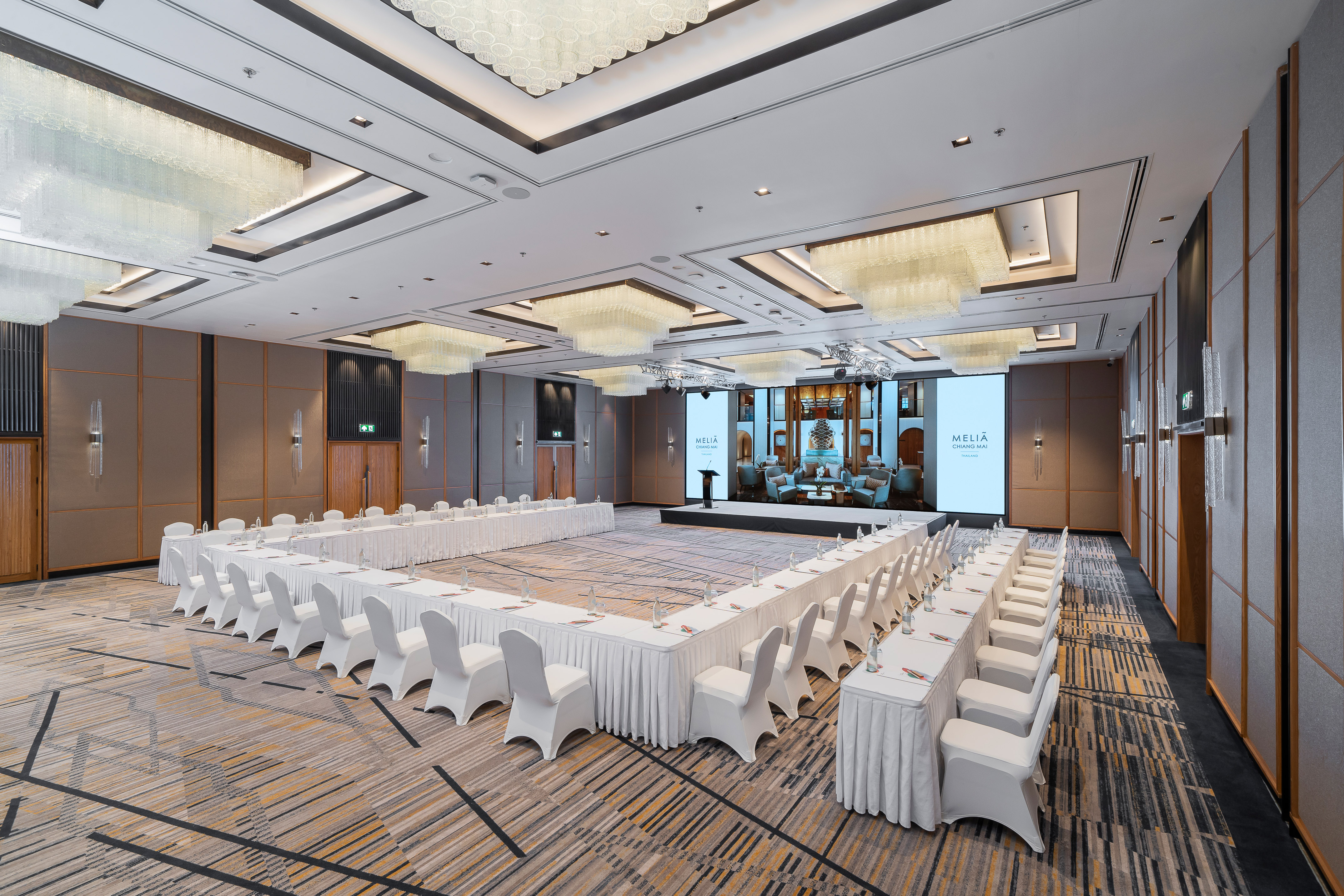 Meliá Chiang Mai ballroom with U-shaped conference setup, large screen.