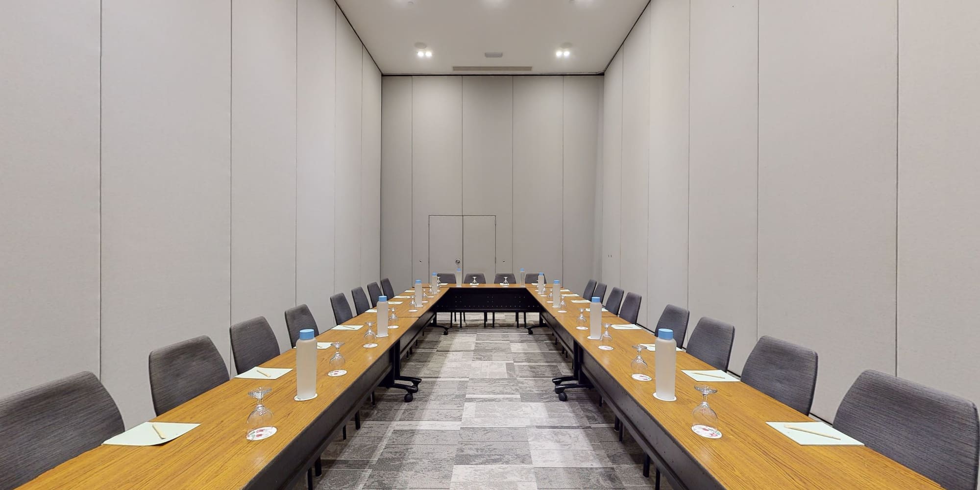 a long table with wine glasses and chairs in a room