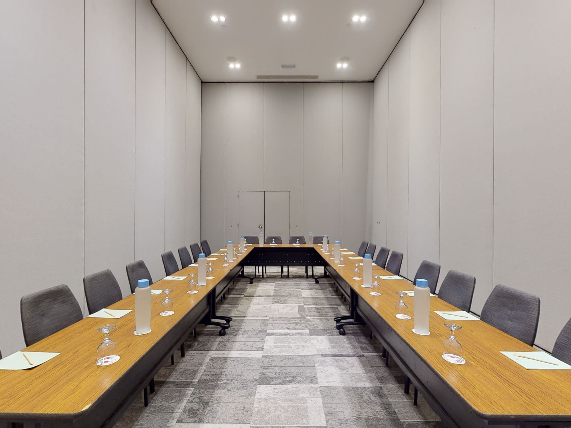 a long table with wine glasses and chairs in a room