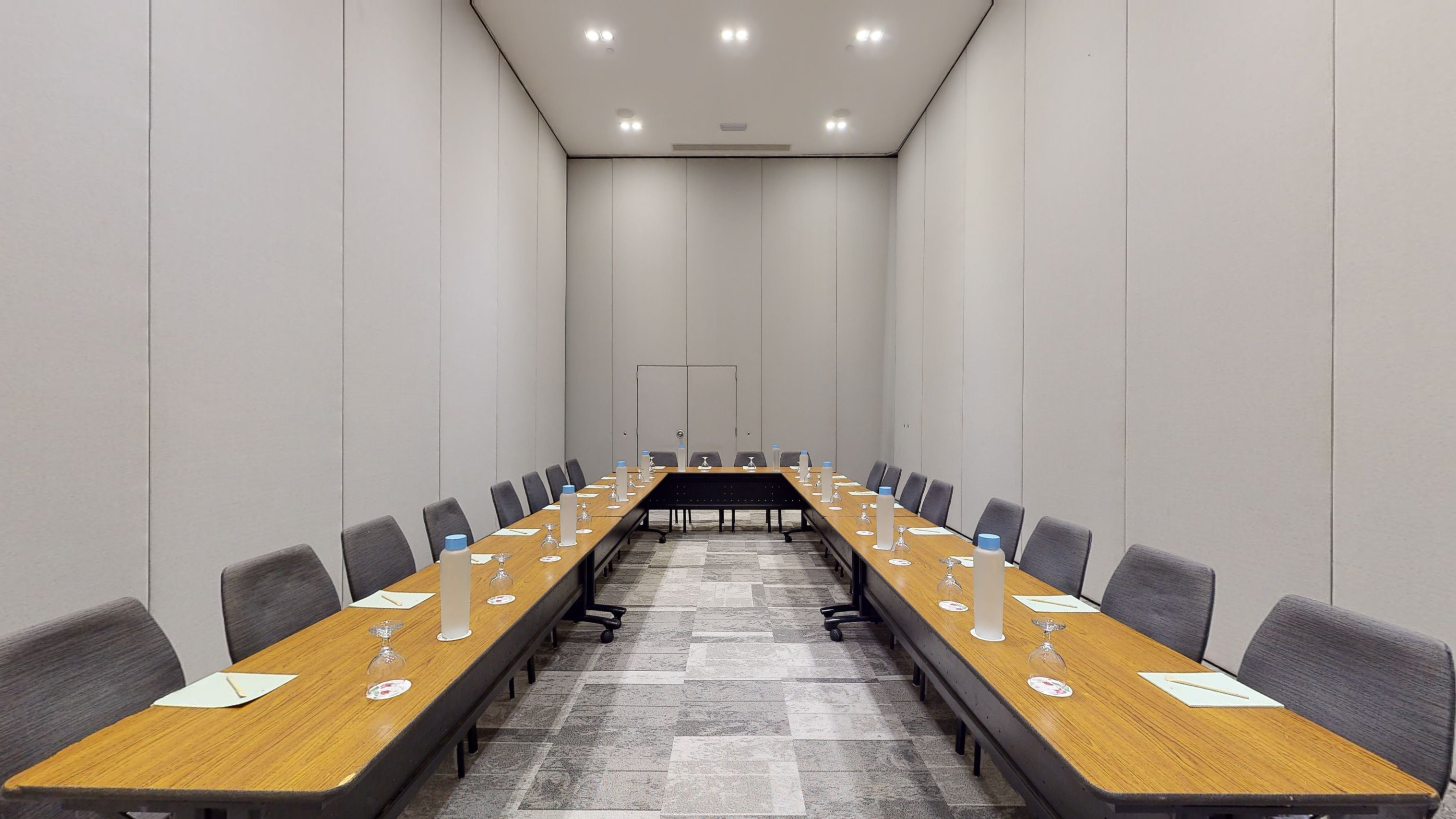 a long table with wine glasses and chairs in a room