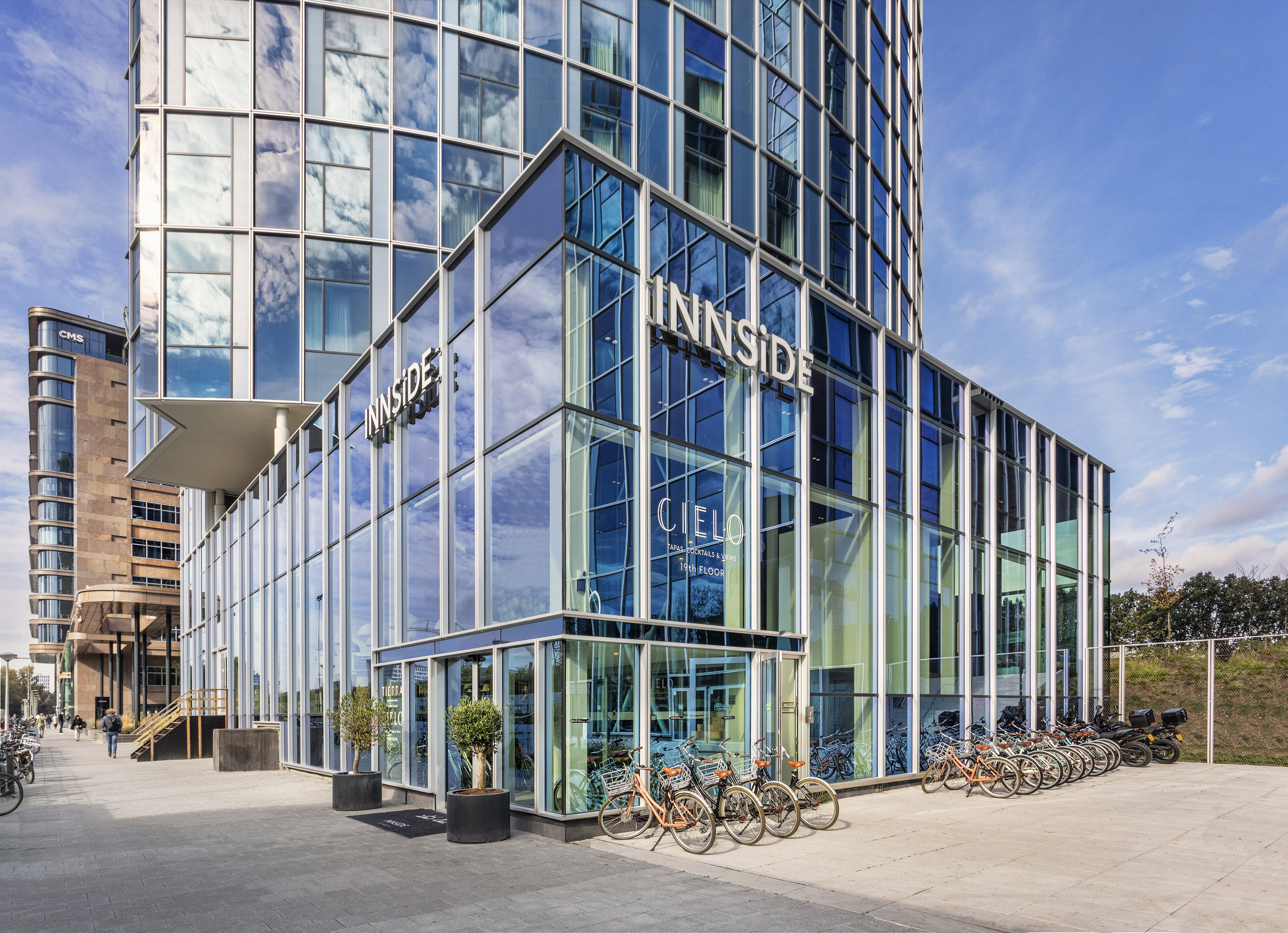 a glass building with a lot of bicycles parked in front of it
