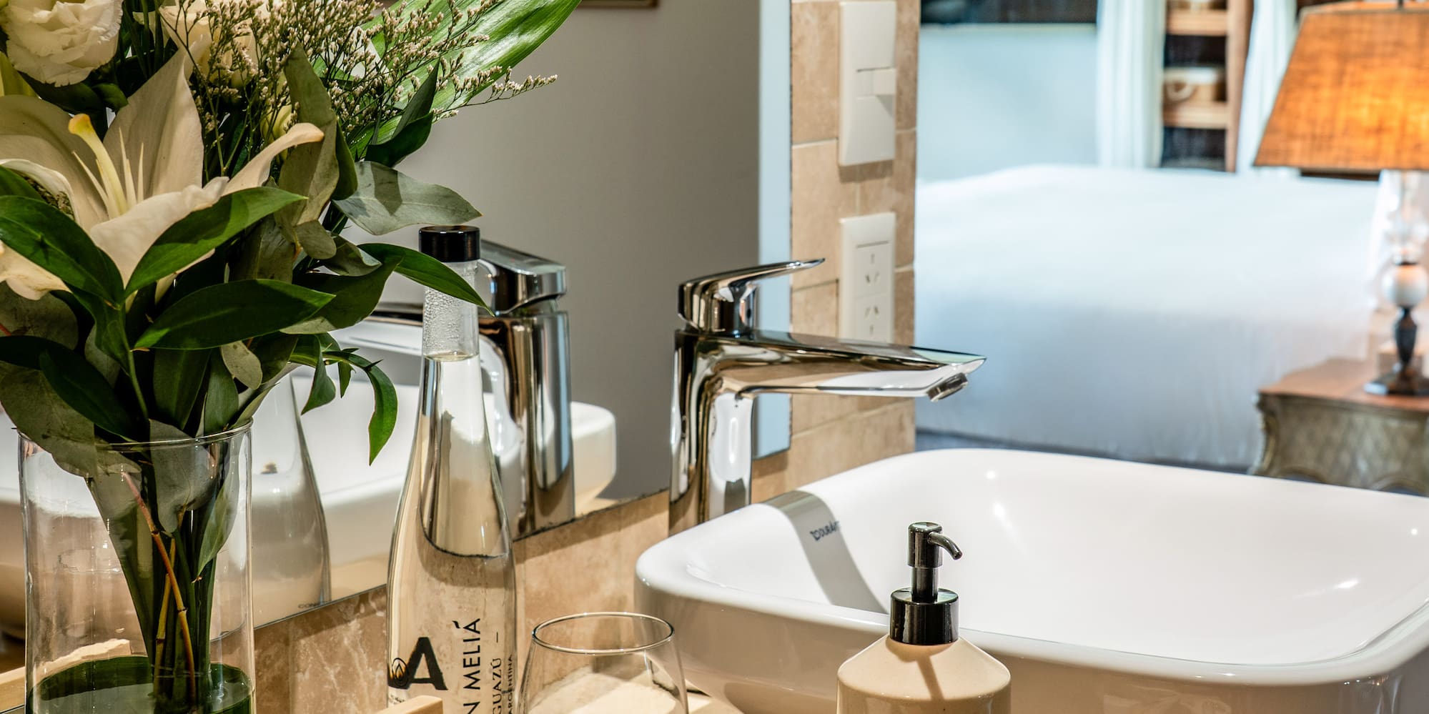 a bathroom with a vase of flowers and a sink