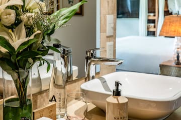 a bathroom with a vase of flowers and a sink