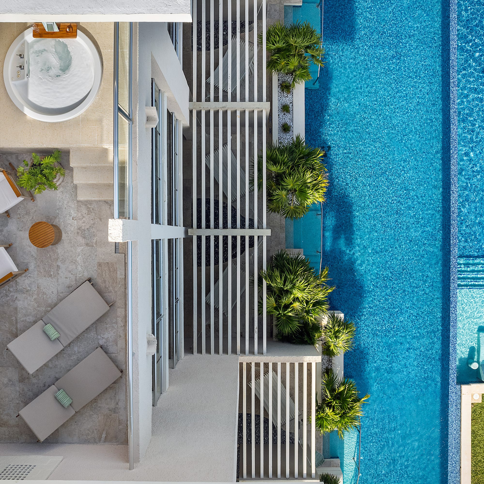 a swimming pool with a jacuzzi and a white building