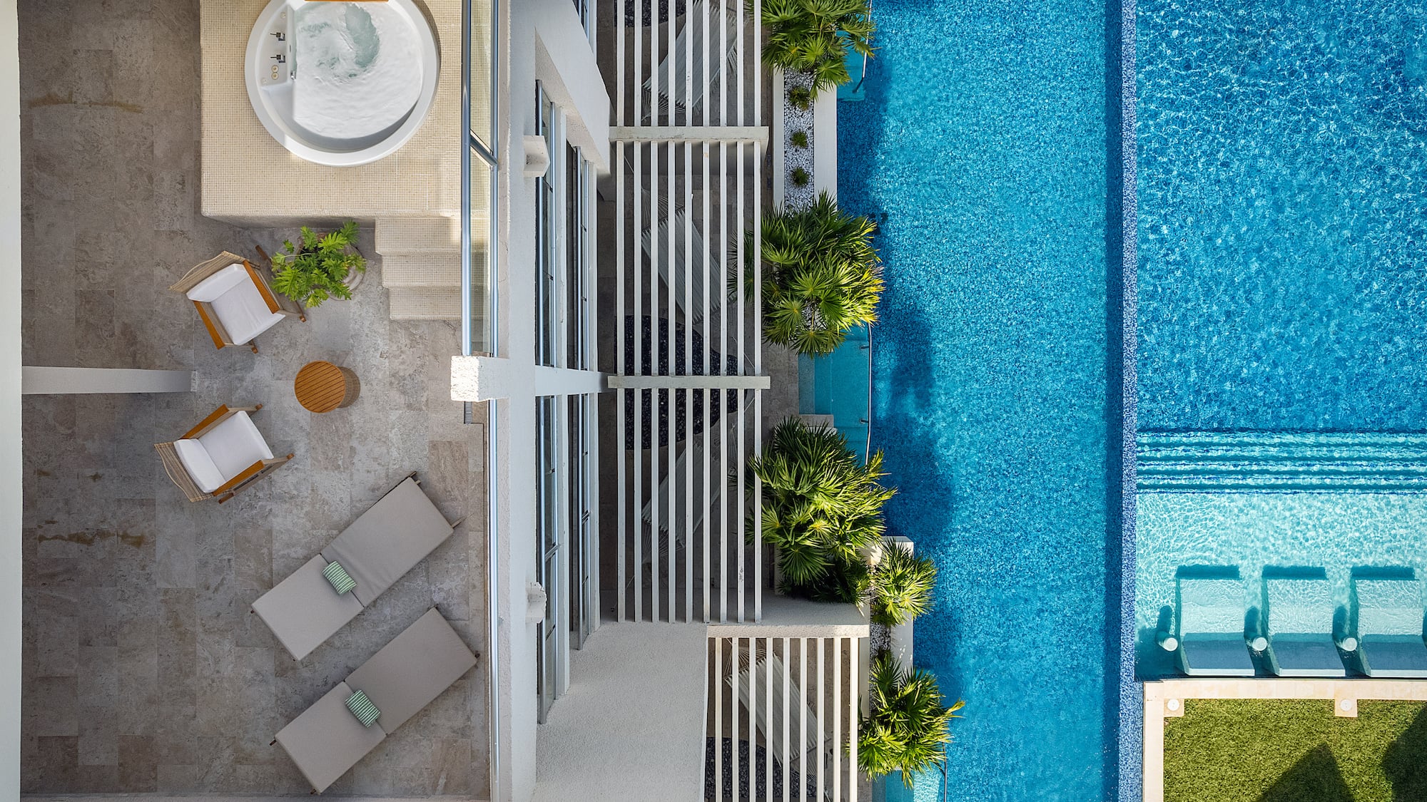 a swimming pool with a jacuzzi and a white building