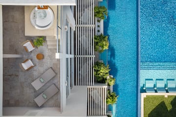 a swimming pool with a jacuzzi and a white building