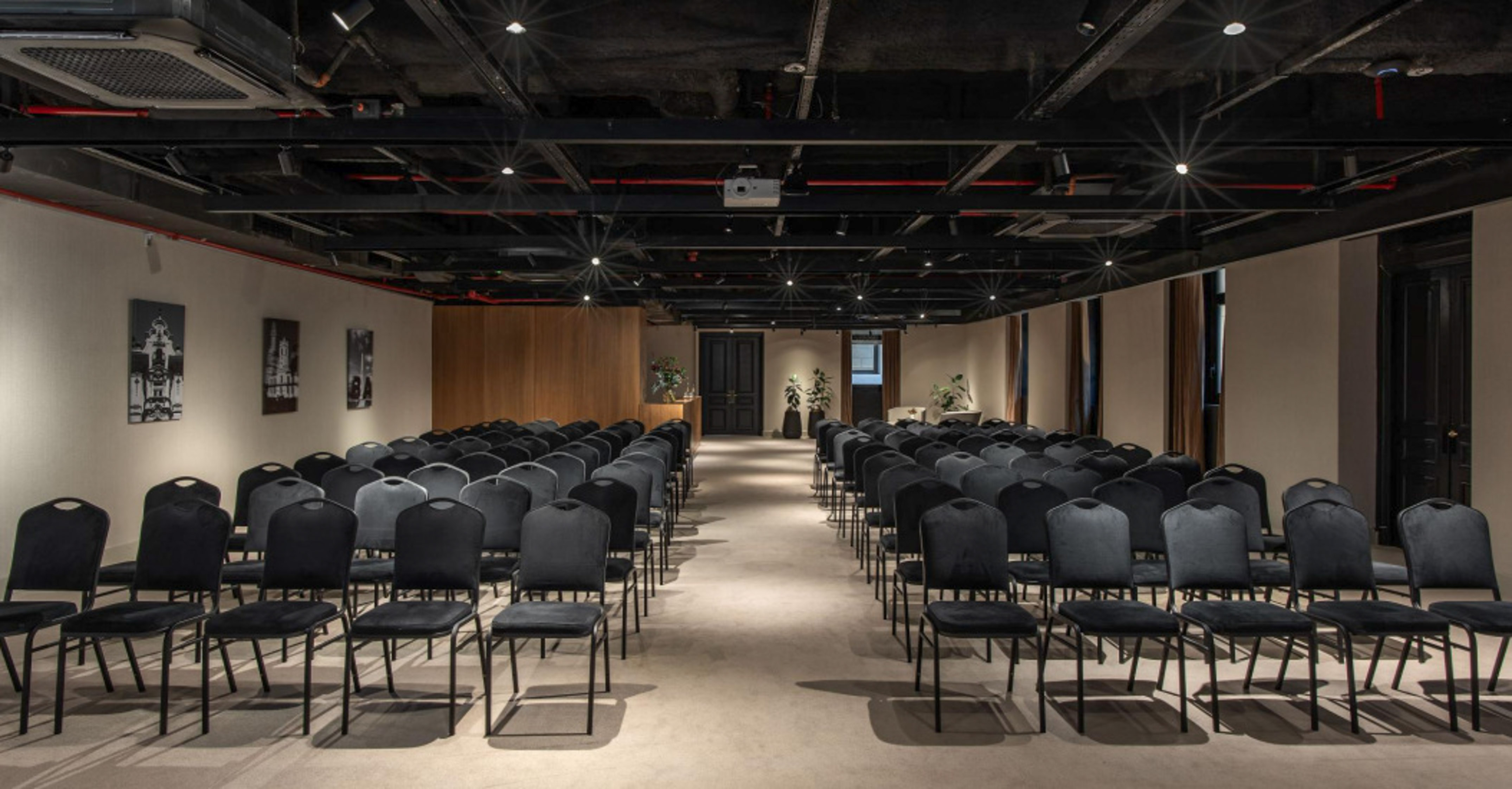 Modern conference room with rows of black chairs and projector for meetings.