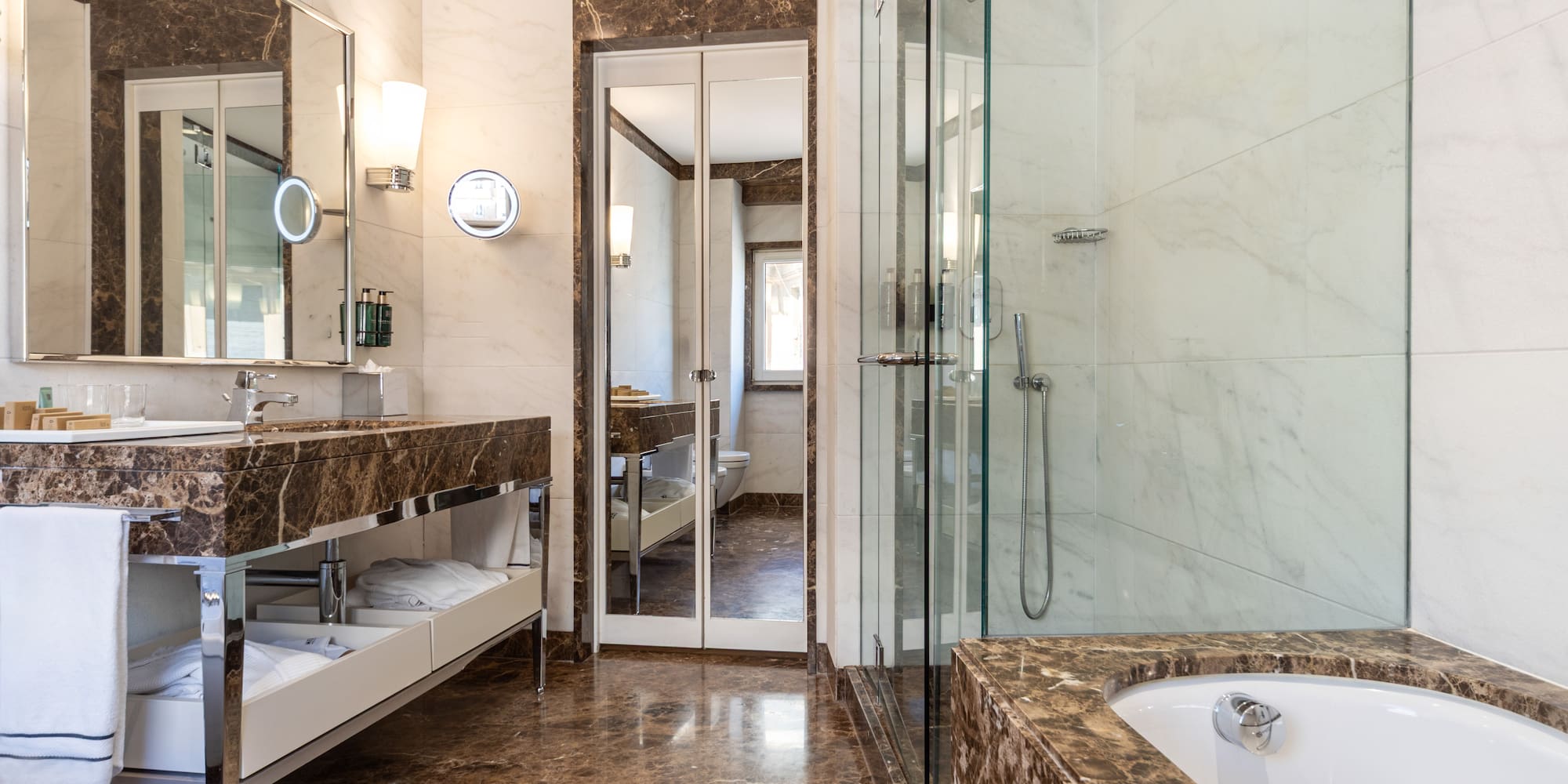 a bathroom with marble countertops and a glass shower